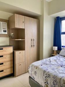 宿务Horizon 101 - champito's place的一间卧室配有一张床和一个木制橱柜