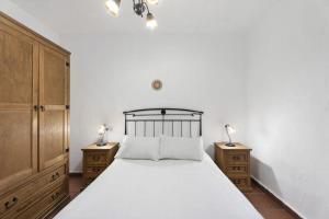 莫卡诺尔Apartamentos Trebol的一间卧室配有一张带2个床头柜和2盏灯的床。