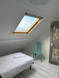 滨海图维列Grande maison de pêcheur - centre de Trouville的一间卧室配有一张床和一张蓝色椅子