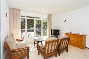 布拉内斯Apartamentos Blanes-Condal Costa Brava的客厅配有两把椅子和电视