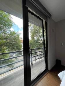 墨西哥城Acogedor con balcón! Depto a 5min Parque Delta的卧室内的大窗户,享有阳台的景色