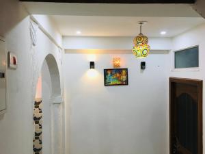 斋浦尔Ali Baba Hostel的走廊上设有吊灯和白色墙壁