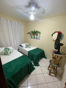 安格拉杜斯雷斯Quarto Ponta Negra的一间卧室配有两张床、一把椅子和风扇