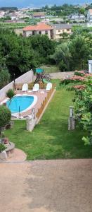 波多诺伏Apartamentos Os Cerros的庭院内的游泳池,带椅子