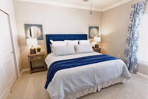 彭萨科拉Luxury 3BR Beach House with Pool and Hot Tub的一间卧室配有蓝色和白色的床以及两盏灯。
