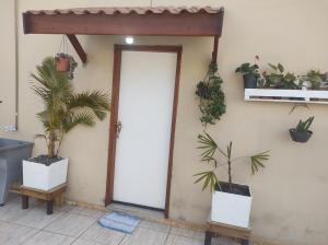 奥兰布拉QUARTO CONFORTAVEL COM GARAGEM的墙上挂着盆栽植物的敞开的门