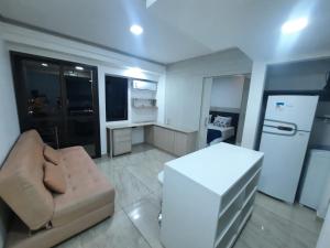 圣保罗Flat Apart-hotel QI Ibirapuera Perto do Shoping的带沙发和冰箱的小客厅