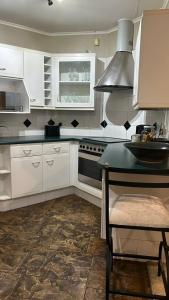 比勒陀利亚741 Tetra Self Catering Accommodation的厨房配有白色橱柜和黑炉。