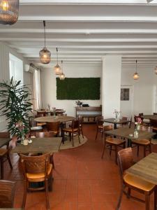 吉利勒杰Gilbjerg Strandhotel的一间带桌椅和绿屏的餐厅
