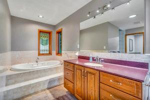 De SotoEagles Landing- Scenic 4 bedroom 5 bath sleeps 15的带浴缸、水槽、浴缸和镜子的浴室
