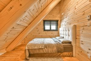 圣多纳特蒙卡尔姆Le Chalet Enchanté的木制客房内的一间卧室,配有一张床