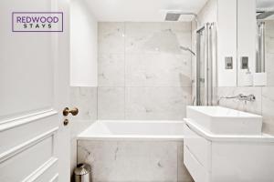 雷丁Premium 1 Bed 1 Bath Apartments For Corporates By REDWOOD STAYS的白色的浴室设有浴缸和水槽。