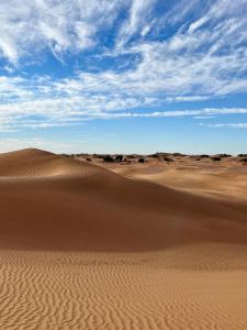 El GoueraChegaga Luxury Camp的沙丘和蓝天的沙漠