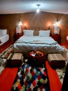 El GoueraChegaga Luxury Camp的一间卧室配有一张带地毯的大床