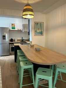 滨海图维列Grande maison de pêcheur - centre de Trouville的厨房配有一张大木桌和绿色凳子