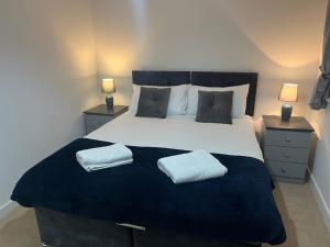 德比Kingsway House - Brand New Spacious 4 Bed Home From Home的一间卧室配有一张大床和两个枕头