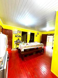 兰舒凯马杜Sítio Nature的黄色客房内的一间卧室配有一张大床