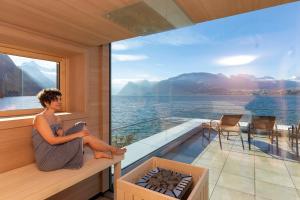 格蒙登Seegasthof Hois'n Wirt - Hotel mit Wellnessbereich的坐在水景阳台的人