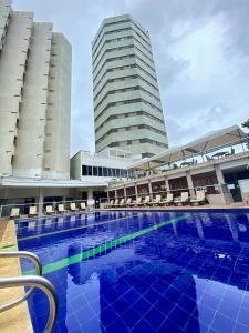 卡塔赫纳Hotel Dorado Plaza Bocagrande的一个大型游泳池,有两栋高大的建筑背景