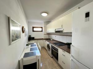 加拉奇科Precioso y Luminoso Piso的厨房配有白色橱柜、水槽和洗碗机。