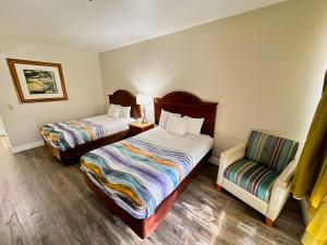 埃尔帕索Americas Hotel - El Paso Airport / Medical Center的酒店客房,配有两张床和椅子