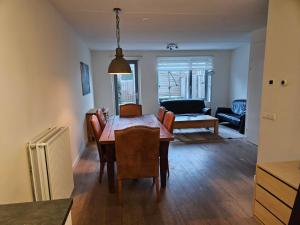 多德雷赫特Residence Dordrecht - 10 persons的用餐室以及带桌椅的起居室。