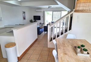 黄金海岸Isle of Palms 31的厨房以及带桌子和楼梯的用餐室。