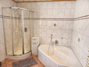 蒂罗尔-基希贝格Pension Wötzinghof的白色的浴室设有浴缸和淋浴。
