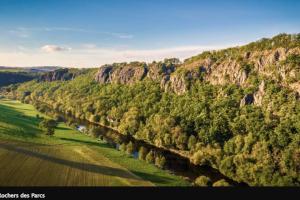 Thury-HarcourtNid douillet en Suisse Normande的享有树木和山脉的河流的空中景致