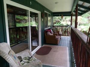 沃尔卡诺Aloha Crater Lodge的一个带椅子和沙发的门廊