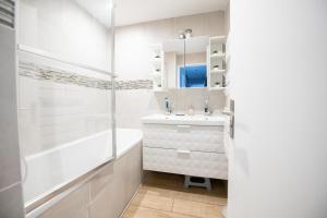 勒布尔热ELISE DE ROCHE Équipé Balcon Parking RER B的白色的浴室设有浴缸和水槽。