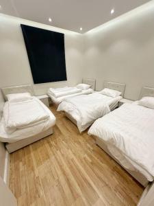 利雅德106 A شقة جميلة بغرفتين نوم ودخول ذاتي的一间设有四张床和平面电视的客房