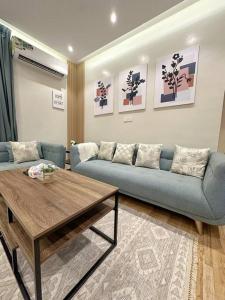 利雅德106 A شقة جميلة بغرفتين نوم ودخول ذاتي的客厅配有蓝色的沙发和桌子