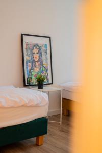 托伦Torun Bridge Apartament的一间卧室配有一张床和一张带绘画的书桌