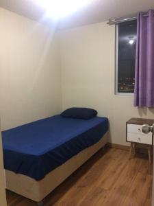 利马Bonito departamento VIP estreno en Condominio的一间卧室配有一张带蓝色床单的床和一扇窗户。