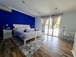 卡拉加尔达纳Galdana's House的一间卧室配有一张蓝色墙壁的床