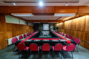 科伊艾科HOTEL NOMADES PATAGONIA的一间会议室,配有长桌子和红色椅子