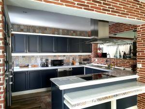 卡拉加尔达纳Galdana's House的厨房配有蓝色橱柜和砖墙