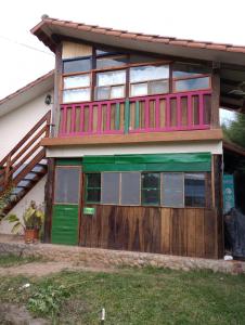 萨迈帕塔Los Aventureros的一座带绿门和木栅栏的房子