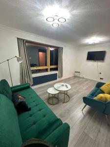 伦敦2 bedrooms apartment in Plaistow near tube to central London的客厅配有绿色沙发和桌子