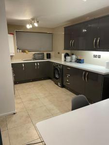 伦敦2 bedrooms apartment in Plaistow near tube to central London的厨房配有黑色橱柜、洗衣机和烘干机