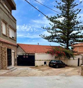 艾因埃尔特克Magnifique Villa avec garage à 2min de la plage Saint-Rock, Ain El Turk, Oran的停车场在带车库的大楼前