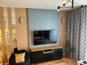奥尔什丁Apartament NOWE POJEZIERZE的客厅设有壁挂式平面电视。