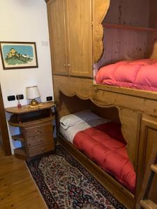 圣维托-迪卡多雷Novità Booking a due passi dalla Ski Area的一间卧室设有两张双层床和床头柜。