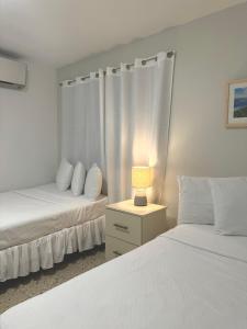 库莱布拉Posada La Hamaca的一间卧室配有两张床和床头灯。