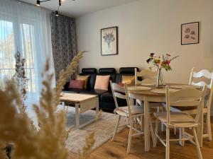 奥尔什丁Apartament NOWE POJEZIERZE的客厅配有桌子和沙发