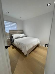渥太华Modern Home for 10+ with Hot Tub!的白色的卧室设有床和窗户