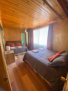 Rio ClaroEl Fogon de Rio Claro的一间卧室设有两张床和木制天花板