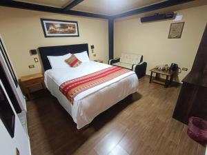 库斯科La Posada del Viajero的一间卧室配有一张大床和一把椅子