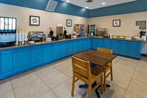 索尔兹伯里江山旅馆及套房 - 索尔兹伯里的厨房配有蓝色橱柜和木桌